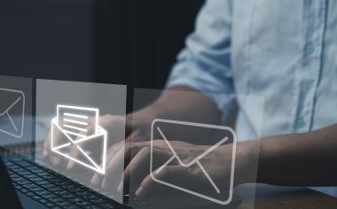 商人在打字著筆記型電腦，開啟並發送電子郵件。